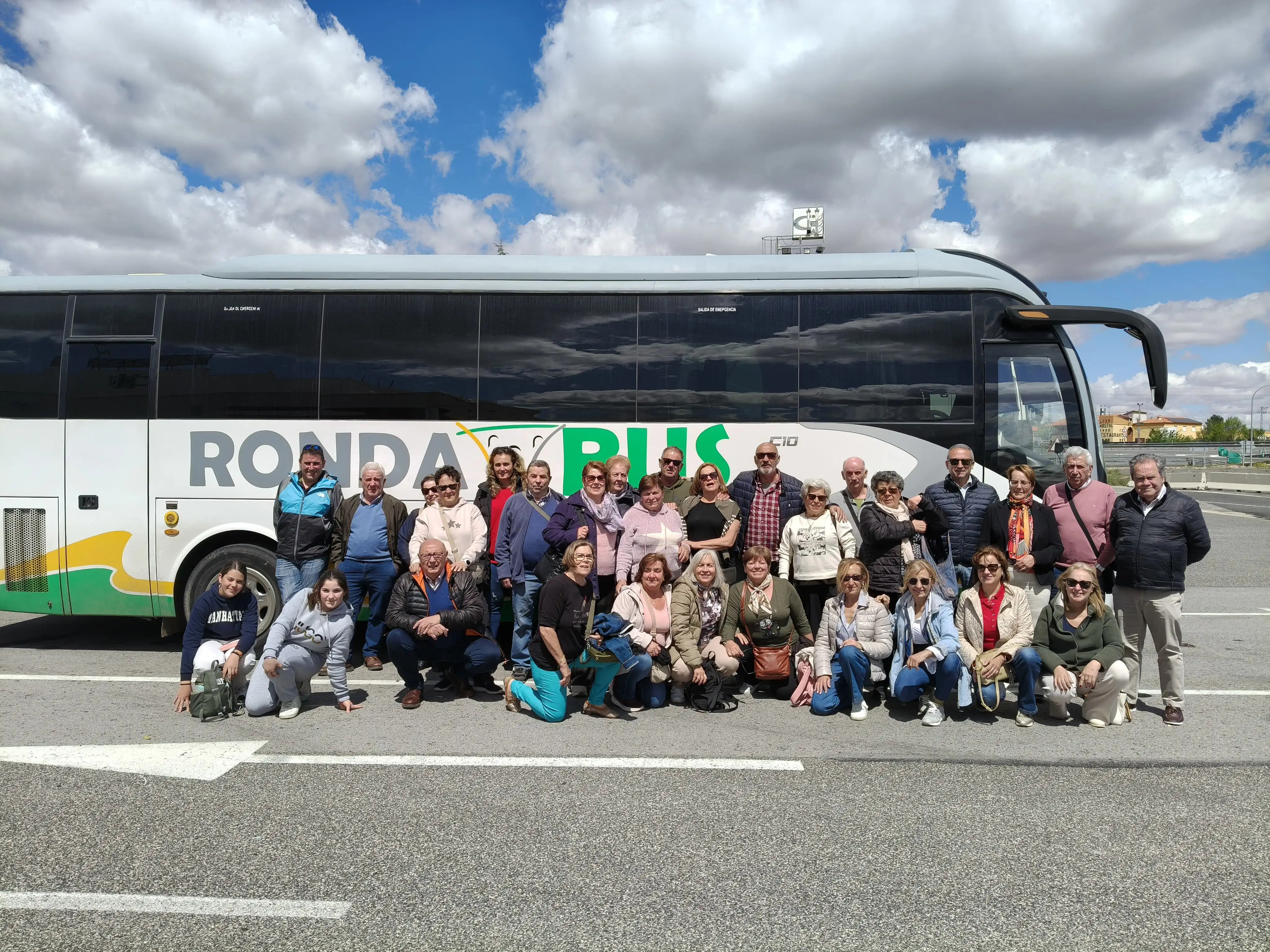 Grupo de viajeros junto a un autocar de Rondabus